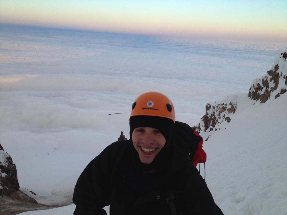 Rodney's photo looking west on top of Mount Hood with Steve smiling and clouds below