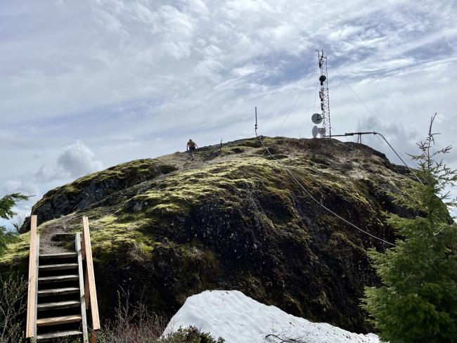 Domed rock summit with wooden stairs providing access in foreground