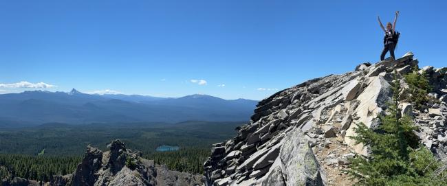 Me standing on summit with view of mountains in background