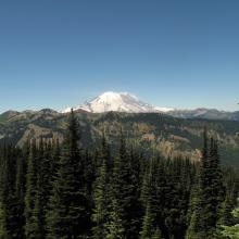 early view of Mount Rainier, with Crystal Mountain Ski Resort peaks in foreground.