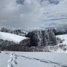 Summit with a little break from the wind and dark skies.