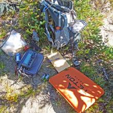 SOTA station in the shade of a scrub pine tree.  Seat Pad, Steno Log Book, KX3, battery.