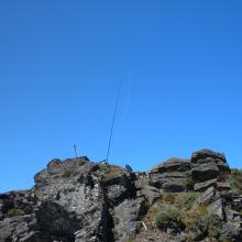 EFHW hanging from mast strapped to old bolt on summit